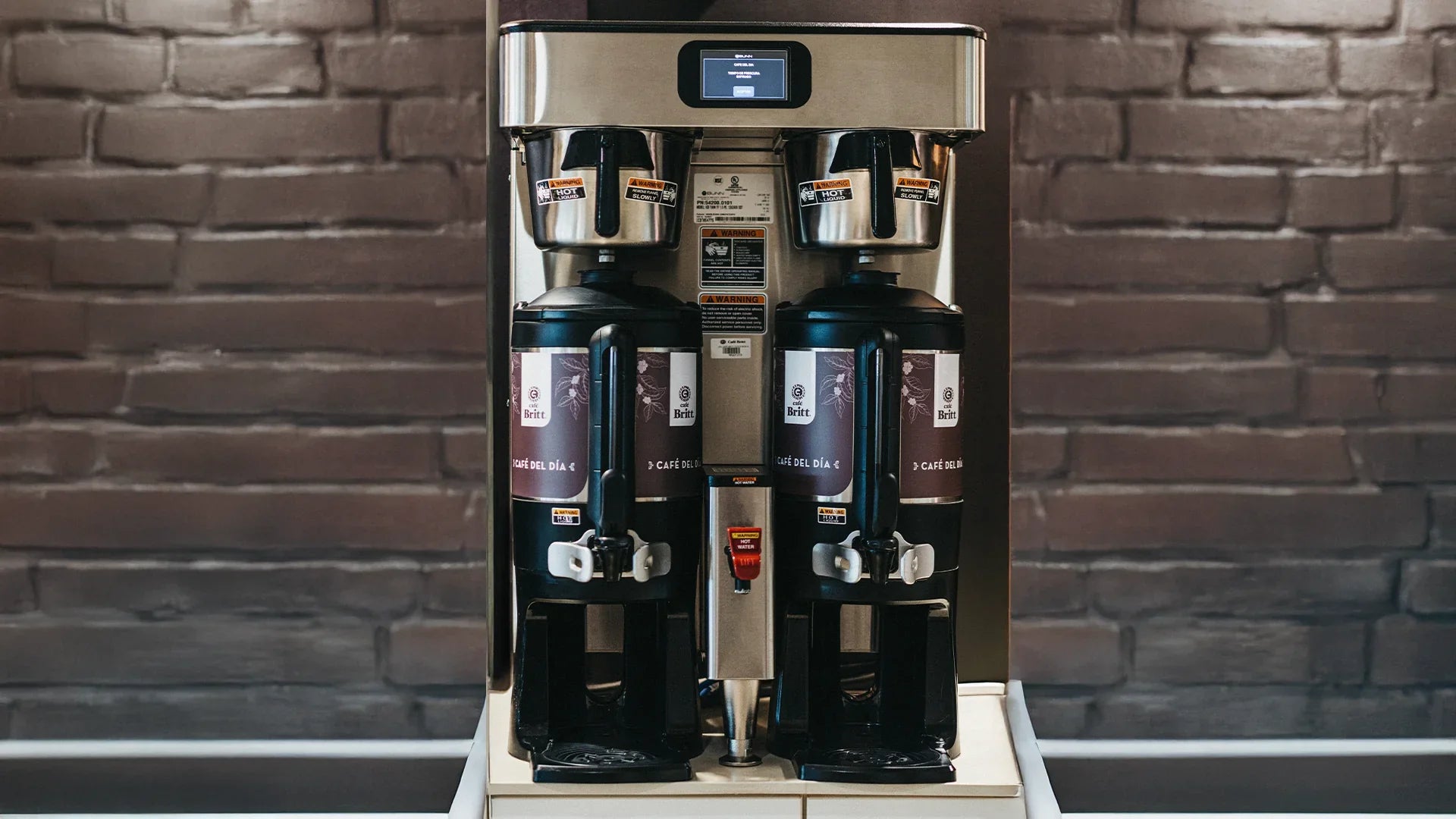 Coffee machine with multiple compartments against a brick wall background