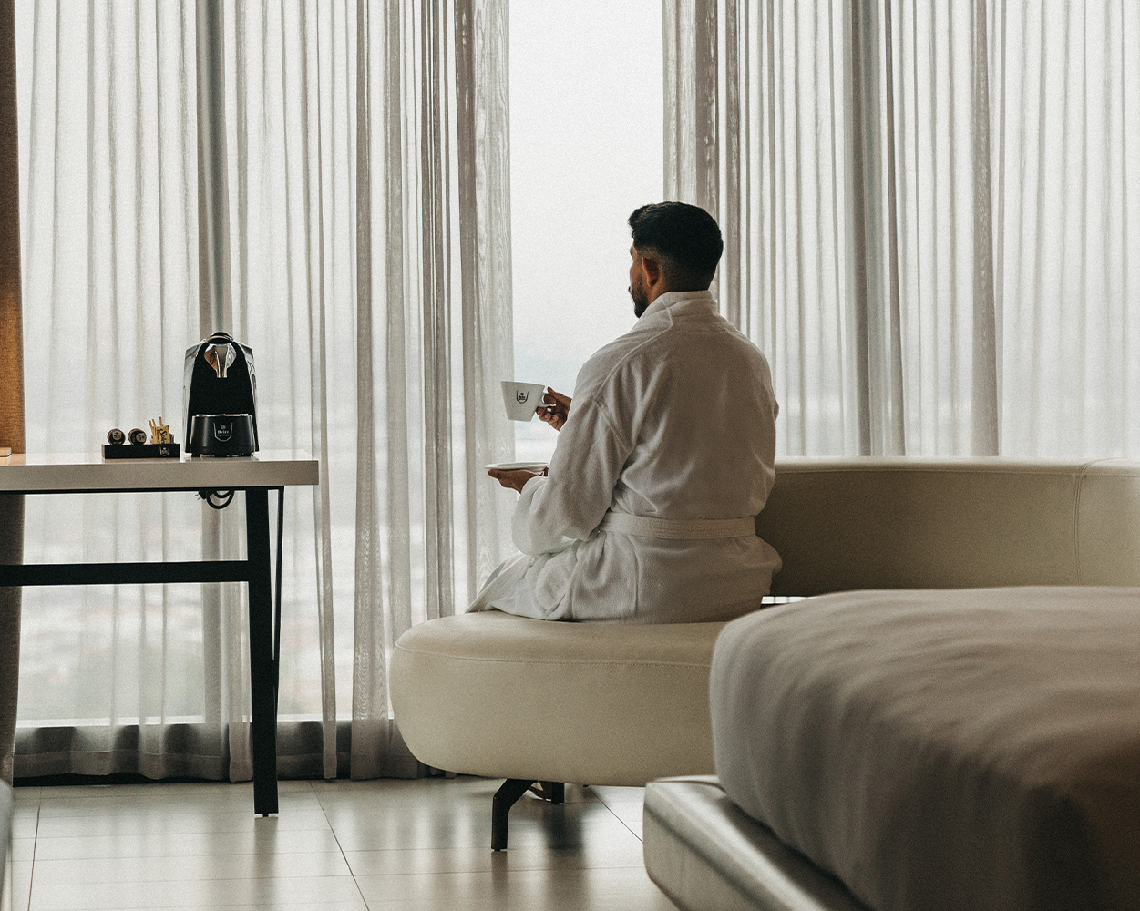 Hotel guest enjoying Café Britt coffee with an in-room coffee machine, enhancing the guest hospitality experience.