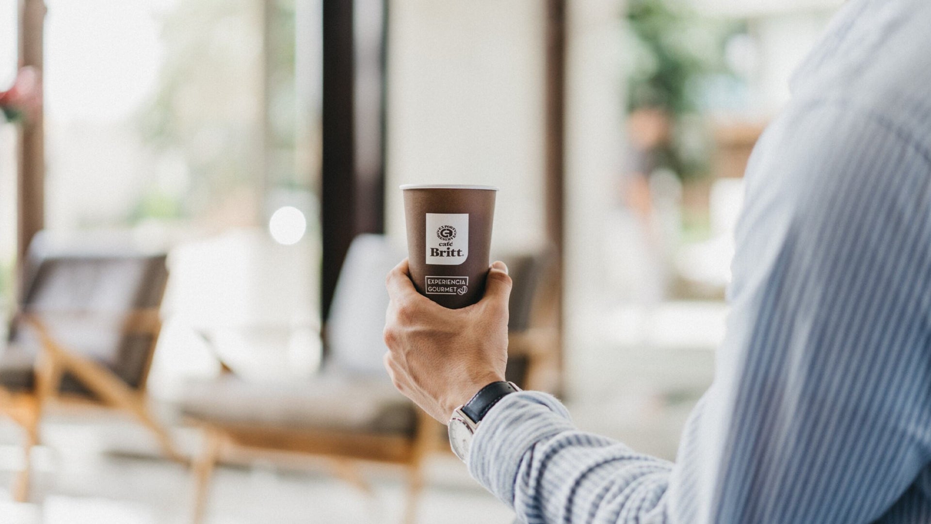 Person Holding a Cafe Britt cup in a lobby