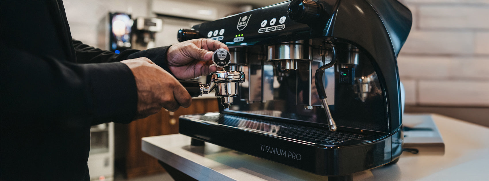 Barista preparing espresso with the Café Britt Titanium Pro commercial coffee machine.