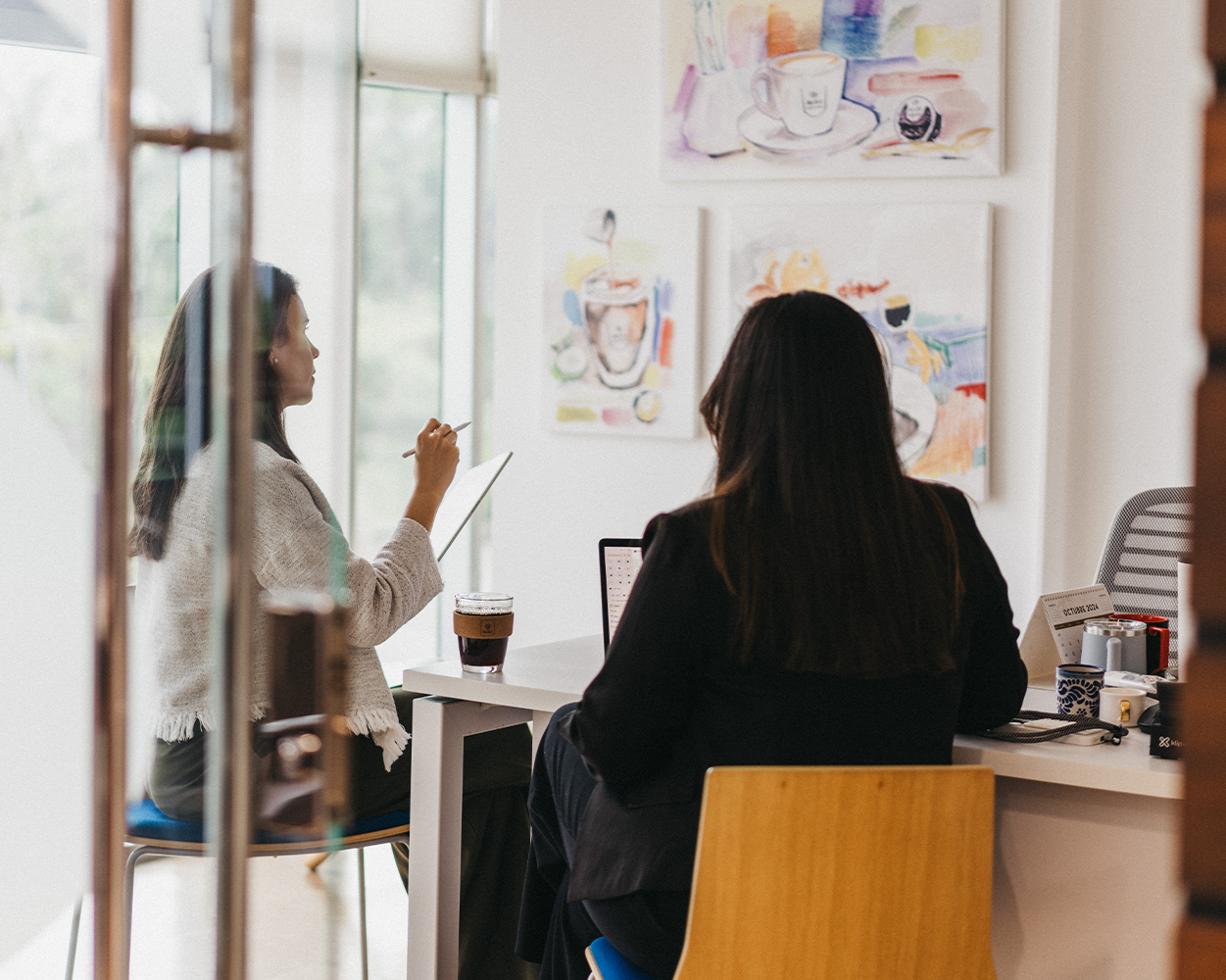 Employees collaborating in a modern office with Café Britt gourmet Costa Rican coffee.