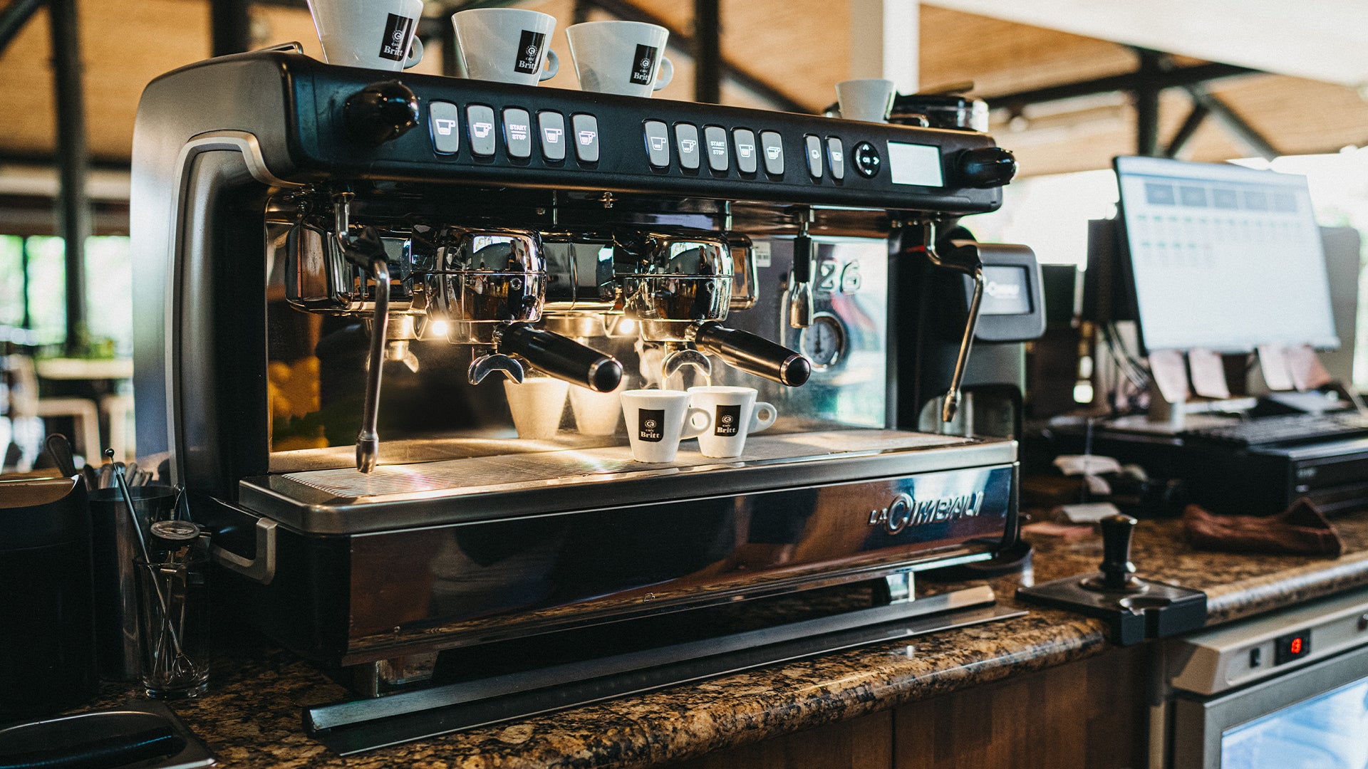 Commercial espresso machine preparing Café Britt gourmet Costa Rican coffee in a restaurant.