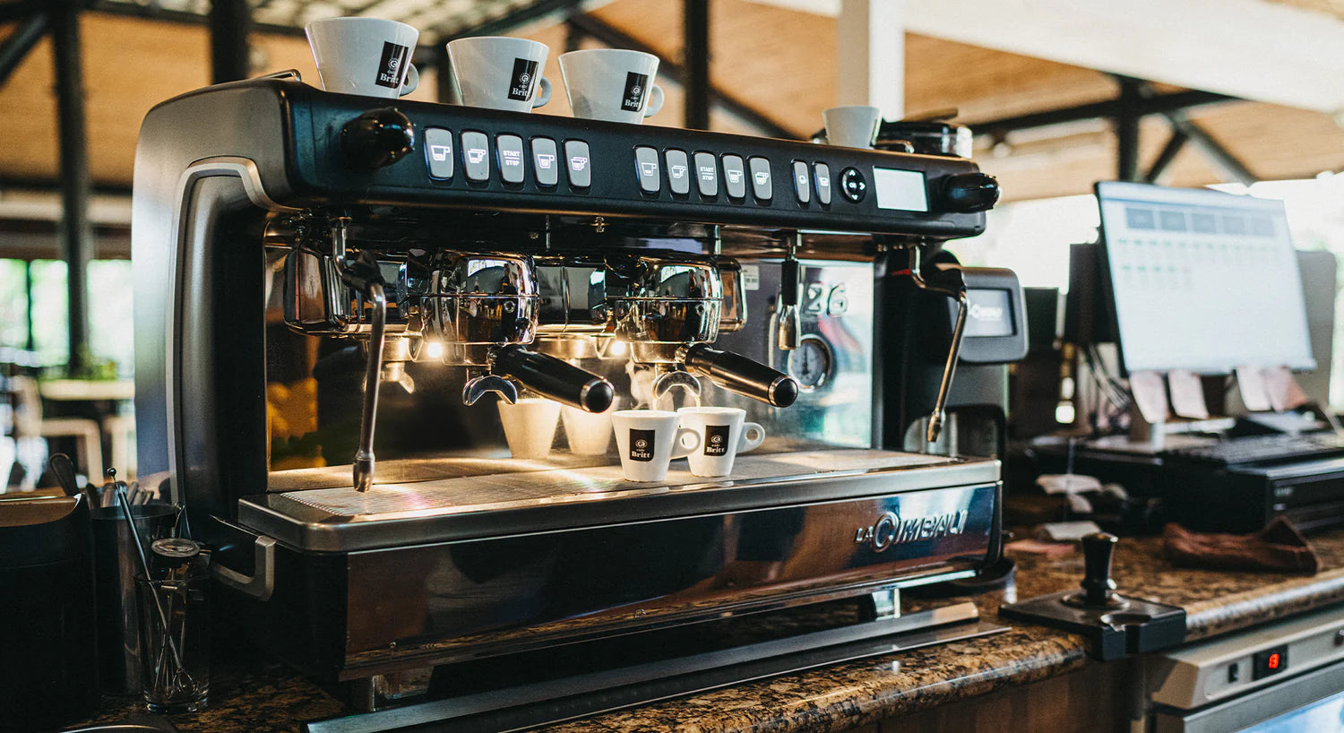 Commercial espresso machine preparing Café Britt gourmet Costa Rican coffee in a restaurant.